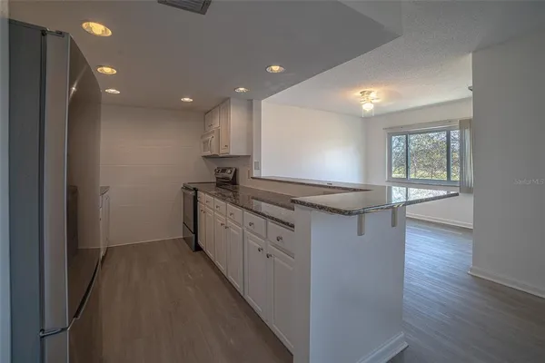 a kitchen with counter top space and wooden floor