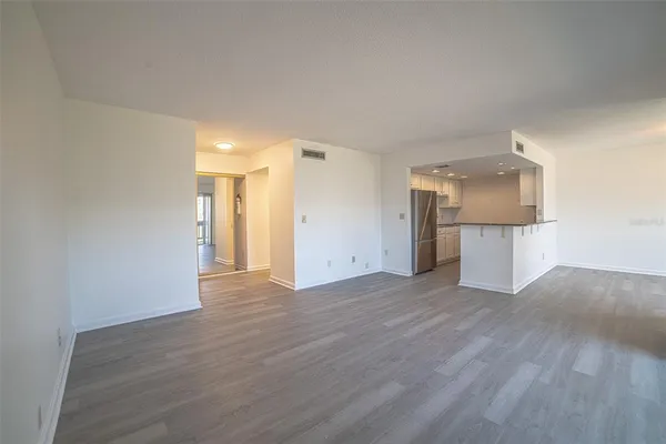 a view of a big room with wooden floor and fireplace