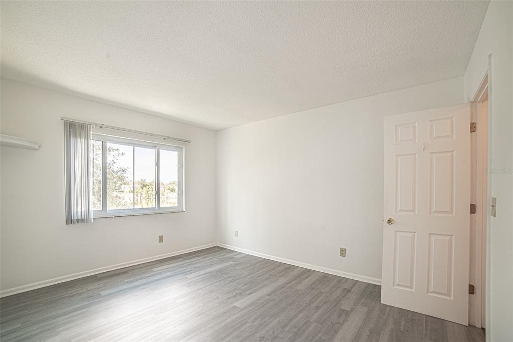 629 North Keene Road, Unit T11 Clearwater, FL 33755 - Photo 9 of 16 an empty room with wooden floor and windows