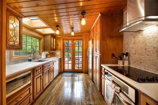 a kitchen with stainless steel appliances granite countertop a stove a sink and a refrigerator