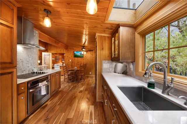 a kitchen with stainless steel appliances granite countertop a sink and wooden cabinets