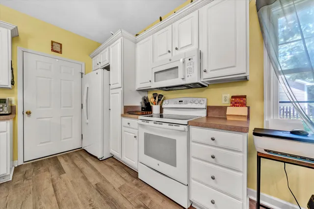 a kitchen with stainless steel appliances white cabinets and a window