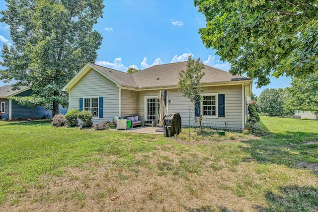 a view of a house with a yard and sitting area