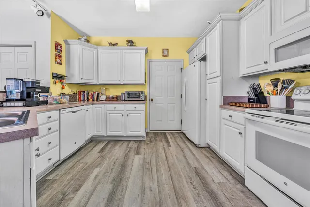 a kitchen with white cabinets and appliances