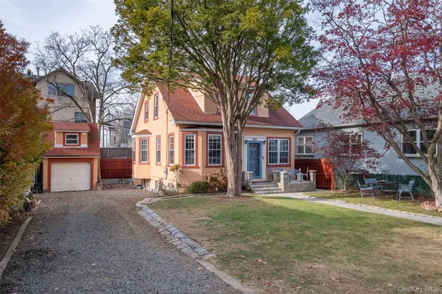 a front view of a house with a yard and trees