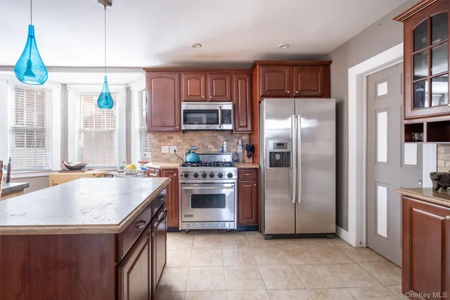 a kitchen with stainless steel appliances granite countertop a stove a refrigerator and a sink