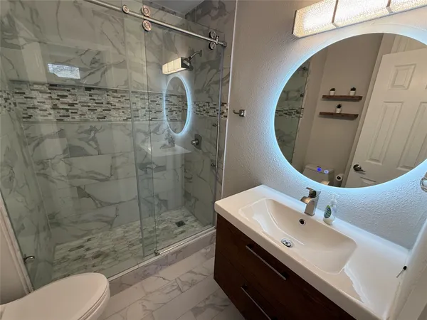 a bathroom with a sink toilet and shower