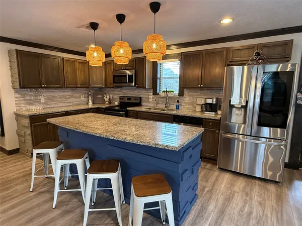 a kitchen with granite countertop stainless steel appliances and wooden cabinets