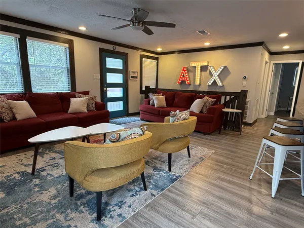 a living room with furniture and a wooden floor