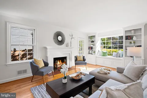 a dining room with wooden floor a chandelier a wooden table and chairs