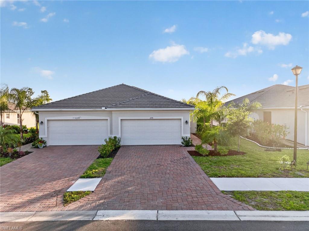 2196 Dragonfruit Way Naples, FL 34120 - Photo 1 of 50 a front view of a house with a yard and garage