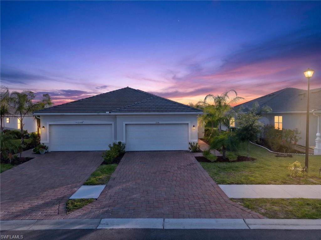 2196 Dragonfruit Way Naples, FL 34120 - Photo 2 of 50 a front view of a house with a yard and a garage