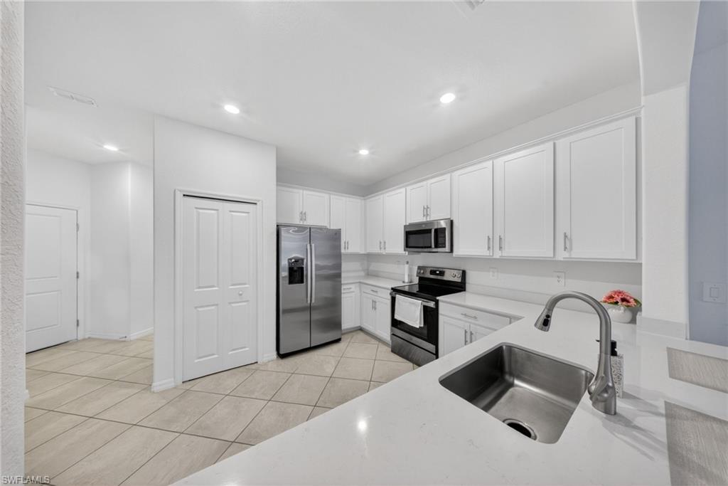 2196 Dragonfruit Way Naples, FL 34120 - Photo 7 of 50 a kitchen with stainless steel appliances granite countertop a refrigerator and a stove top oven