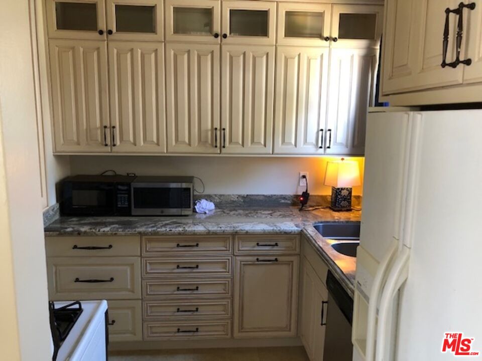 1927 Butler Avenue Los Angeles, CA 90025 - Photo 12 of 19 a kitchen with granite countertop a sink and a stove next to a window
