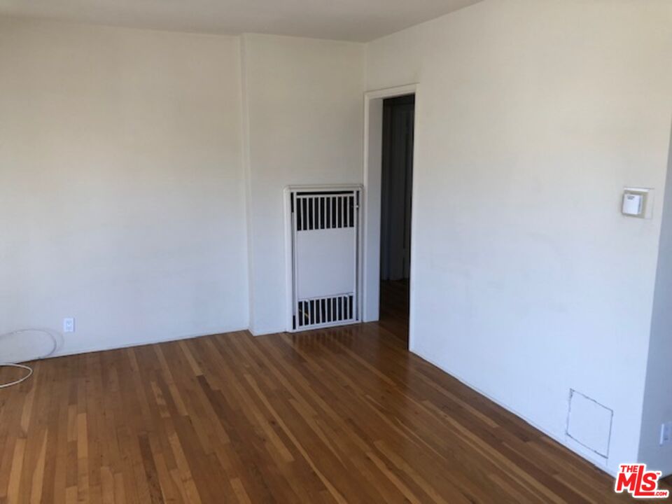 1927 Butler Avenue Los Angeles, CA 90025 - Photo 17 of 19 a view of an empty room with wooden floor and a window