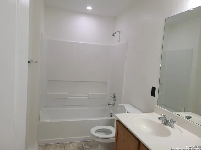 a bathroom with a sink toilet vanity and tub