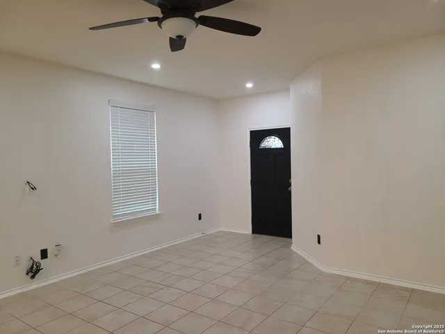 an empty room with fan and windows