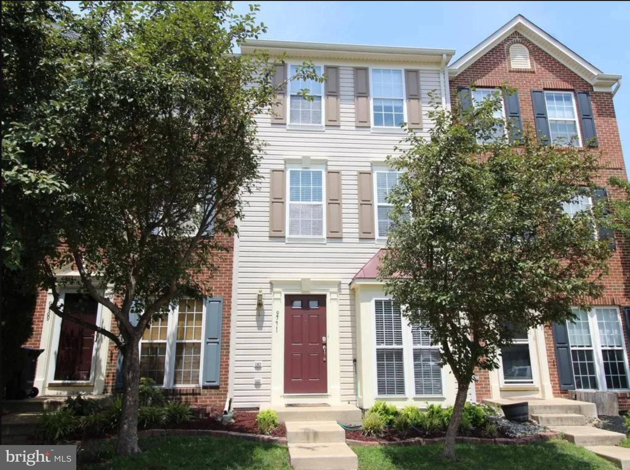 front view of a brick house with a yard