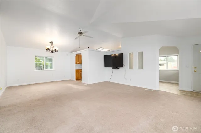 an empty room with windows and fireplace