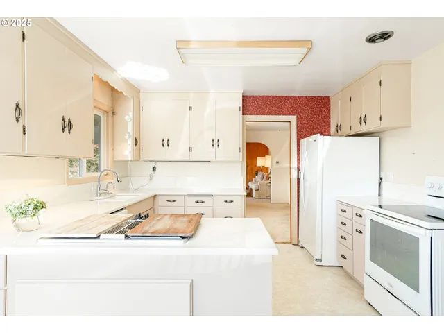 a kitchen with white cabinets and white appliances