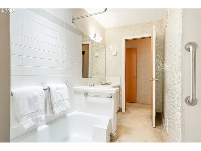a bathroom with a tub sink and mirror