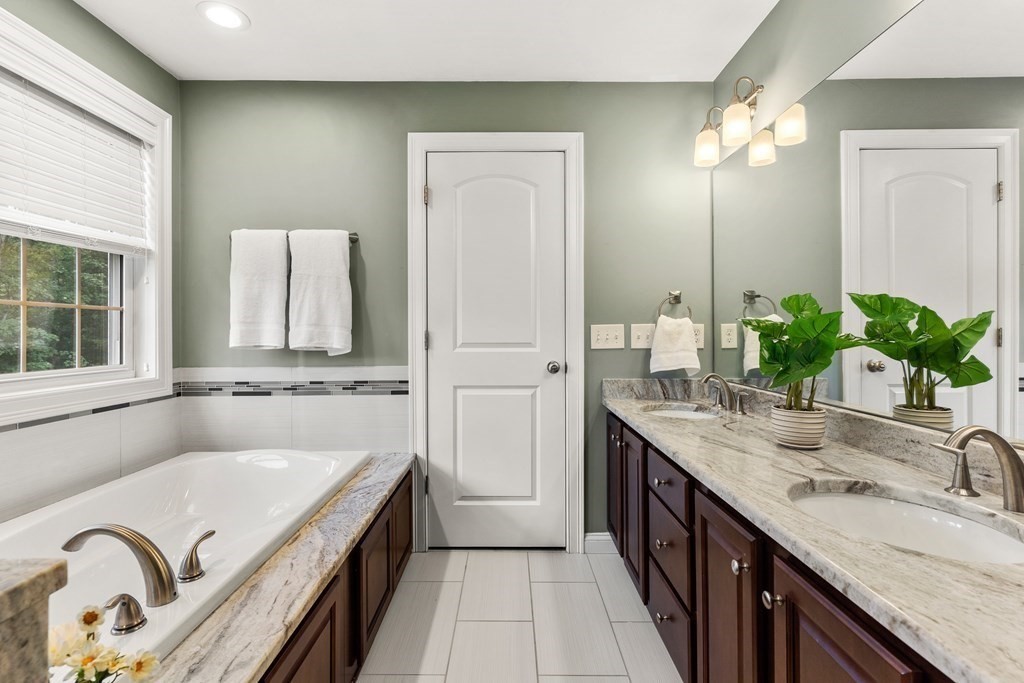 2 Georgianna Road Billerica, MA 01821 - Photo 23 of 41 a en suite bathroom with a granite countertop double vanity sink a mirror and a bathtub