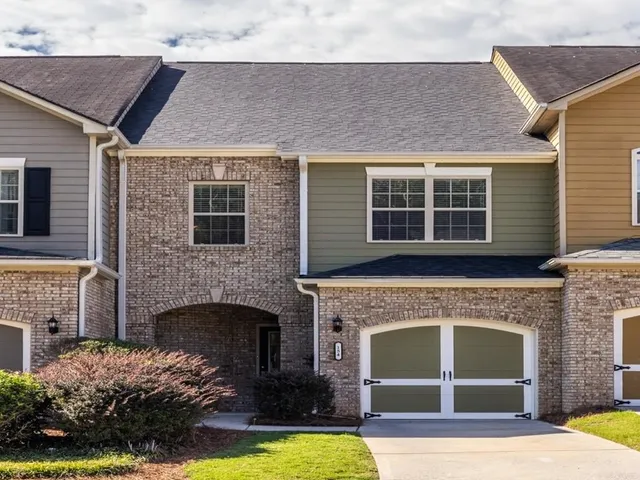 a front view of a house with a garden and yard