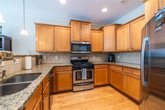 a kitchen with stainless steel appliances granite countertop a stove a sink and a microwave