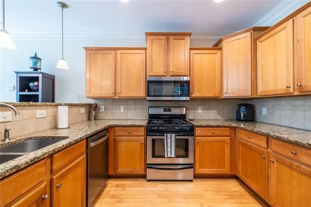 a kitchen with stainless steel appliances granite countertop a sink stove and microwave