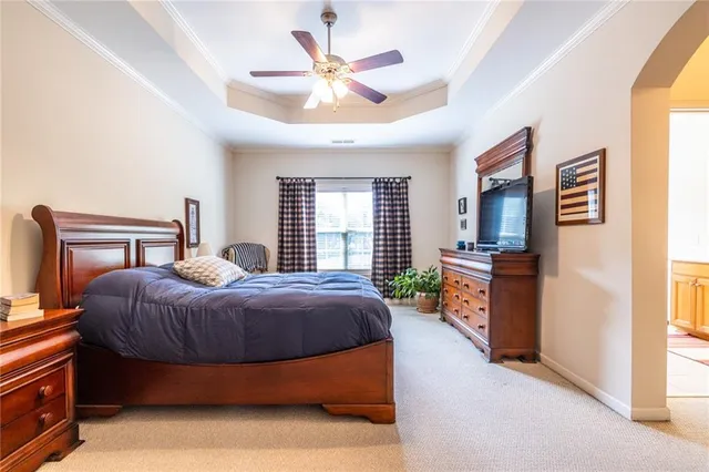 a bedroom with a bed a window and a chandelier