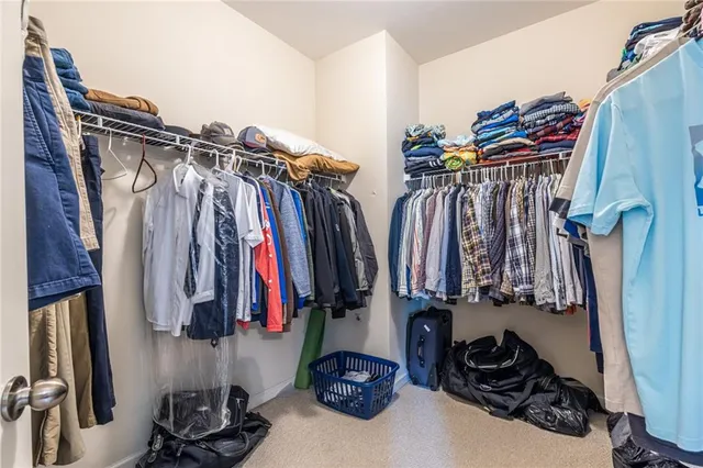a view of walk in closet with clothes and shoes