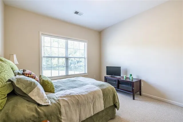 a bedroom with a bed tv and a window