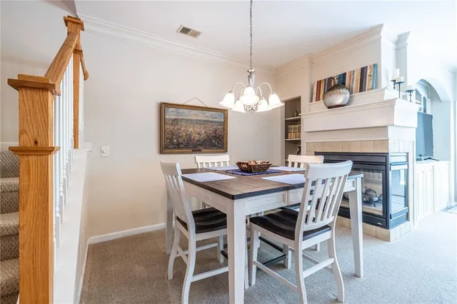 a view of a dining room with furniture a chandelier and wooden floor