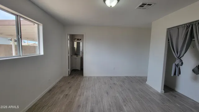 a view of a room that has wooden floor and windows in it