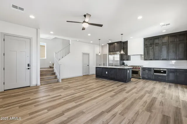 a large kitchen with stainless steel appliances granite countertop a stove a sink and a refrigerator