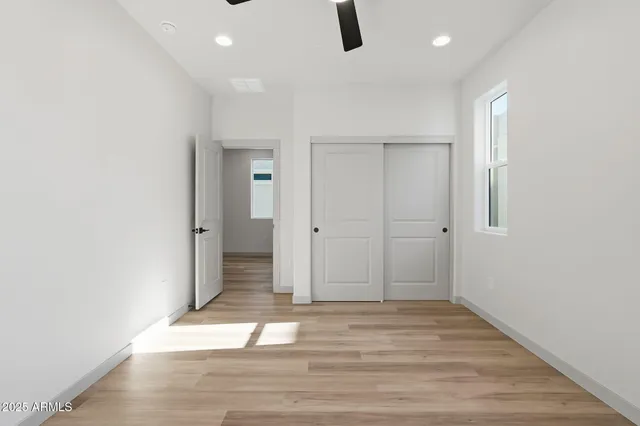 an empty room with wooden floor and window