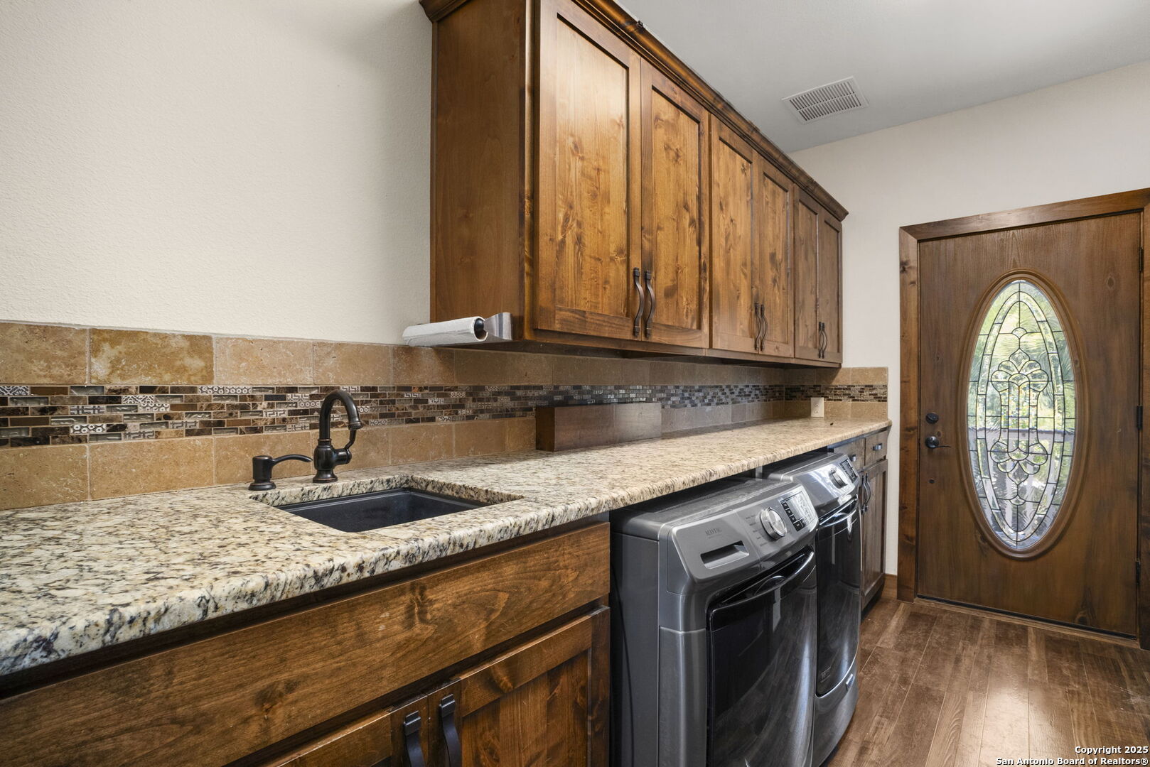 3615 Riverside Drive Kerrville, TX 78028 - Photo 21 of 50 a kitchen with stainless steel appliances granite countertop a sink a stove and a wooden floors