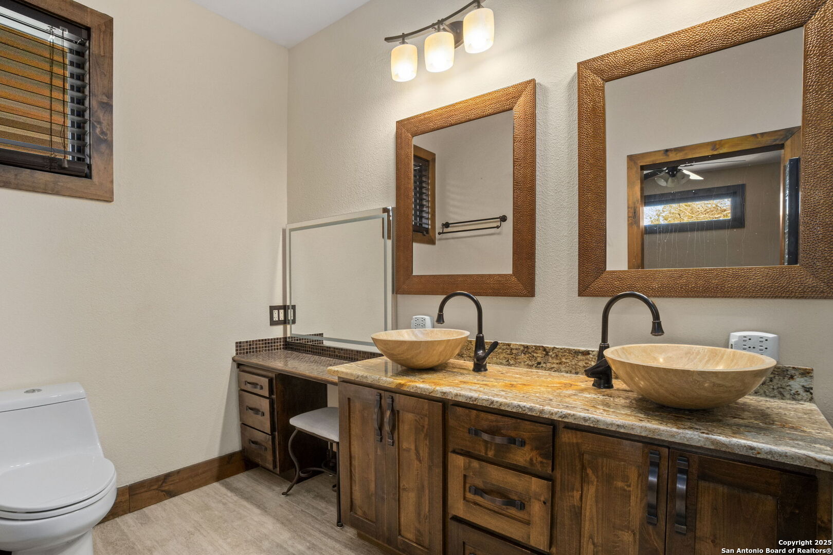 3615 Riverside Drive Kerrville, TX 78028 - Photo 32 of 50 a bathroom with a granite countertop sink a toilet and mirror
