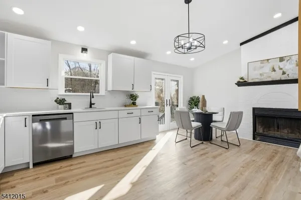 a kitchen with stainless steel appliances granite countertop a stove a sink dishwasher and a refrigerator with wooden floor