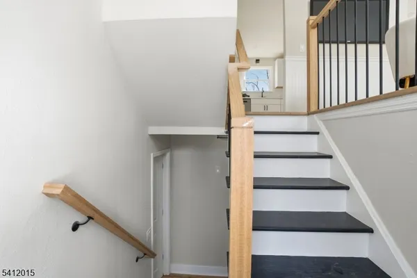 a view of staircase with white walls and a window