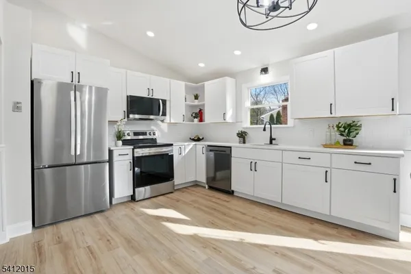 a kitchen with white cabinets and stainless steel appliances