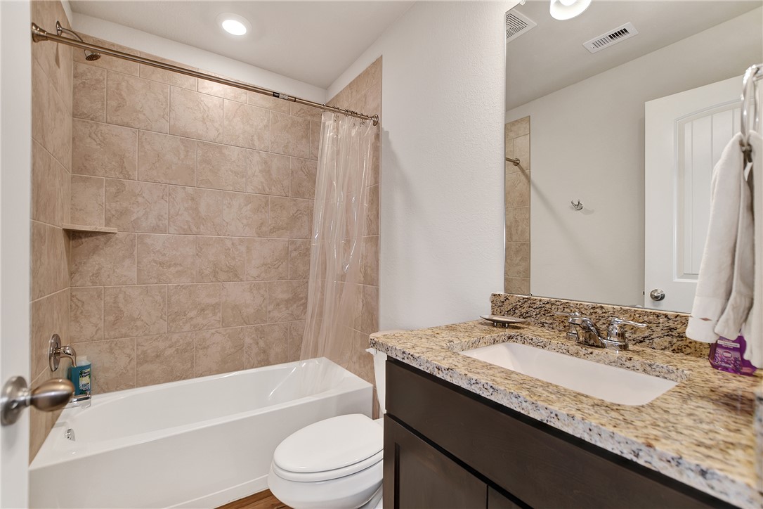 909 Davy Street Brenham, TX 77833 - Photo 24 of 35 Bathroom featuring vanity, shower / bath combo with shower curtain, and recessed lighting