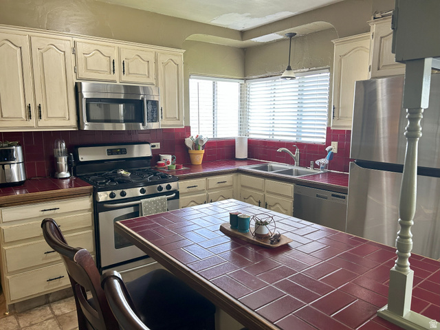 40 South State Street Scipio, UT 84656 - Photo 11 of 39 Kitchen featuring tile counters, stainless steel appliances, hanging light fixtures, and tasteful backsplash