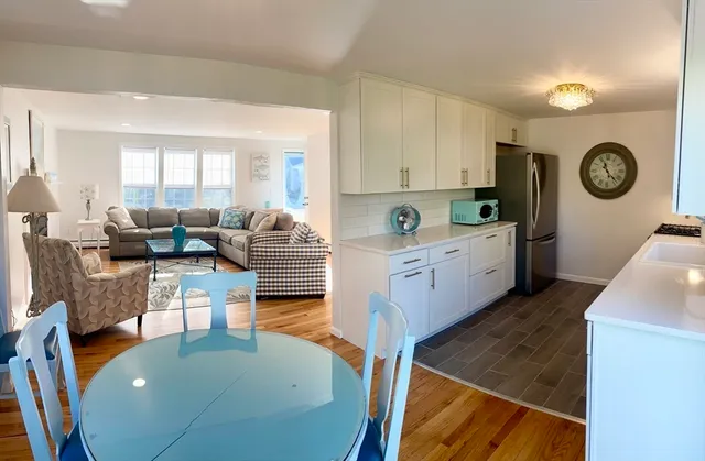 a living room with furniture wooden floor and a large window