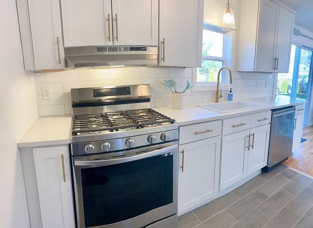 a kitchen with white cabinets and appliances