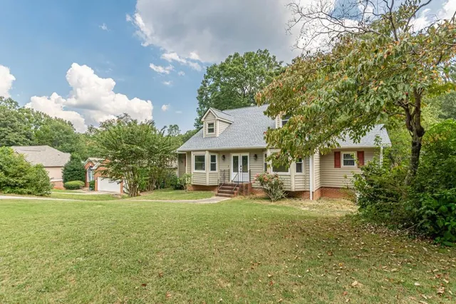 a front view of a house with a yard and trees
