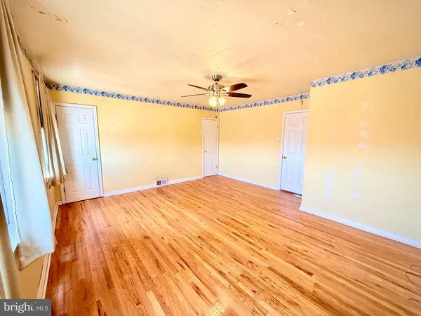 a view of a room with wooden floor and windows