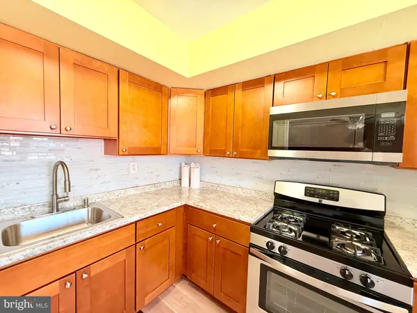 a kitchen with stainless steel appliances a stove a sink and a microwave