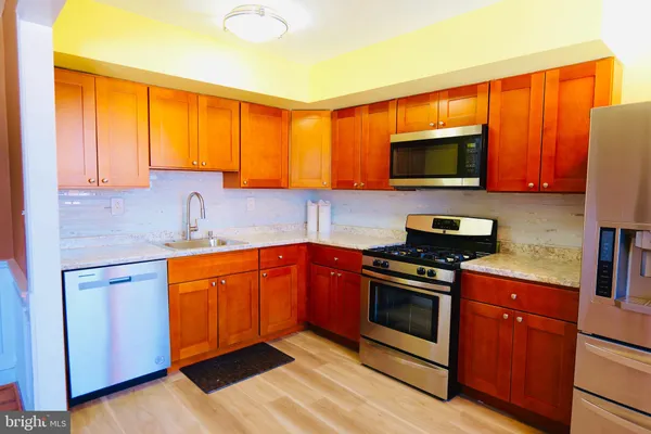 a kitchen with stainless steel appliances a stove a sink and a microwave