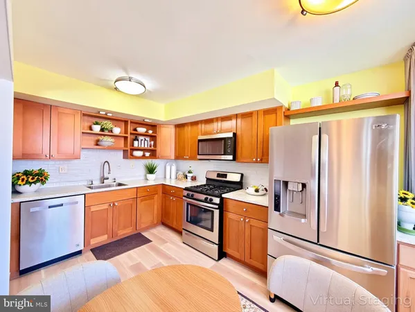 a kitchen with stainless steel appliances granite countertop a refrigerator a stove top oven a sink and dishwasher